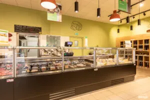 Comptoir réfrigéré vitré présentant divers morceaux de fromage