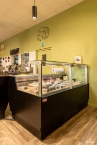 Comptoir réfrigéré vitré présentant divers morceaux de fromage