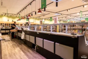 Personne qui découpe de la viande dans une boucherie